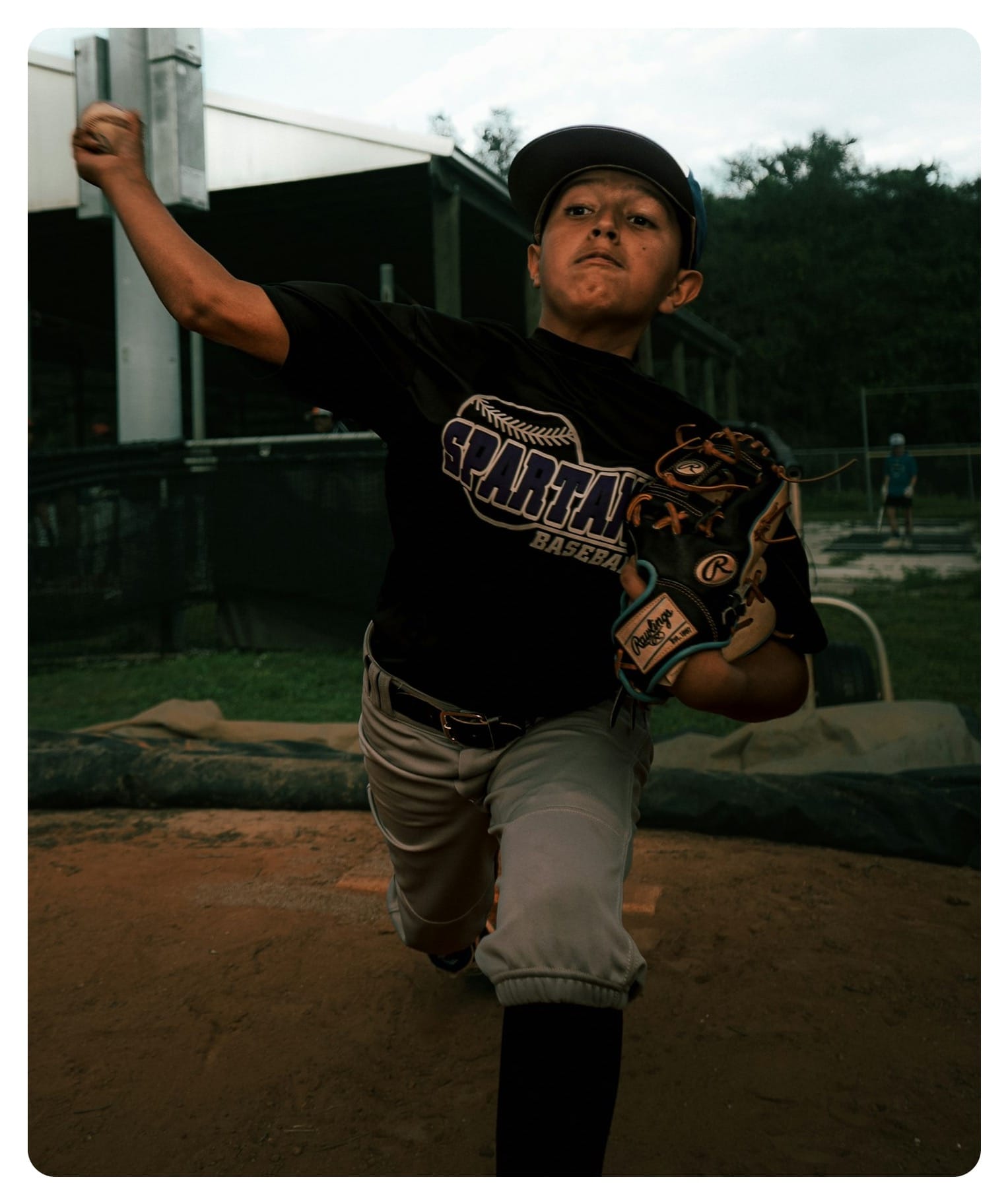 a young boy holding a baseball bat on top of a field
